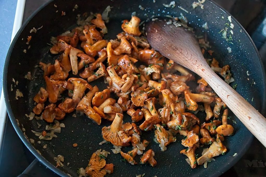 Fresh thyme added to sautéed onions in a frying pan