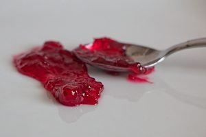 Spoonful of lingonberry jam cooling on plate for wrinkle test.