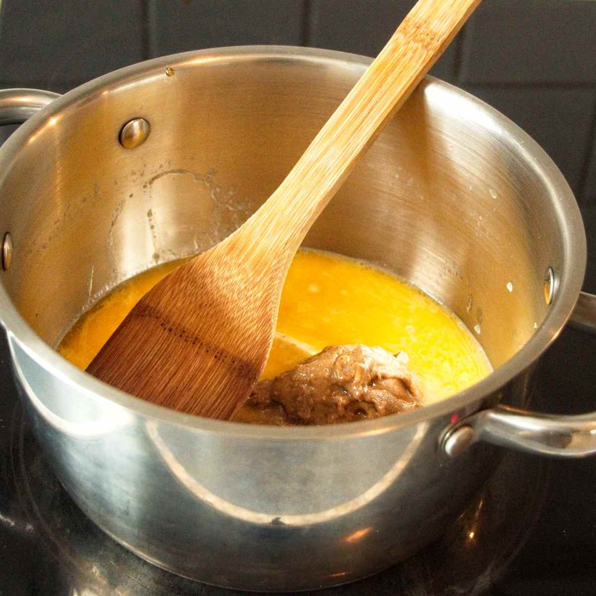 butter and honey melting gently in a saucepan with wooden spoon