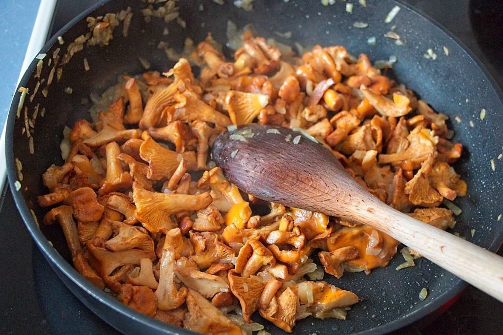 Chanterelles cooking in a pan and releasing their liquid for creamy chanterelle sauce