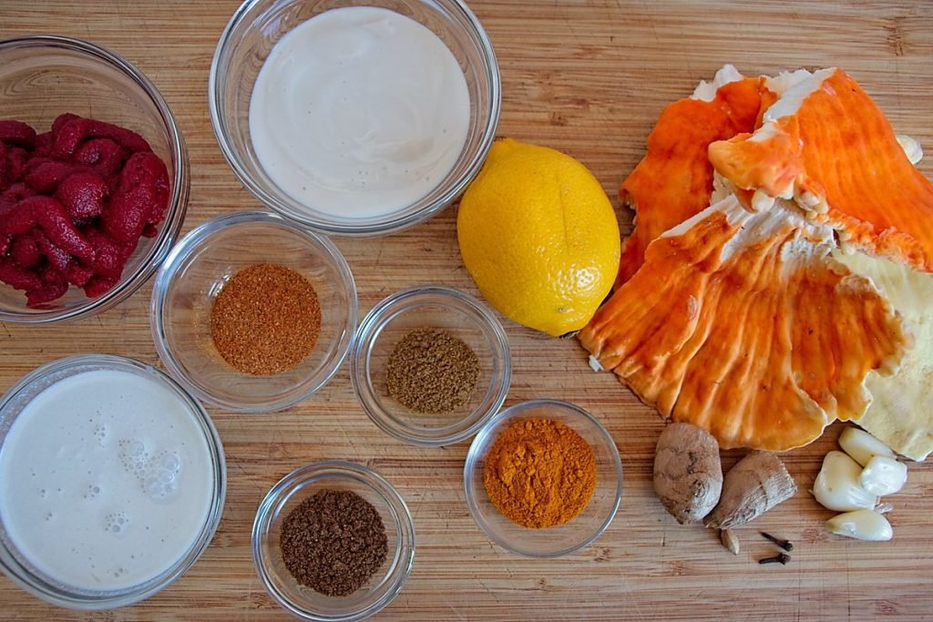 Ingredients for chicken of the woods butter chicken recipe, including mushrooms, spices, lemon, and vegan yogurt