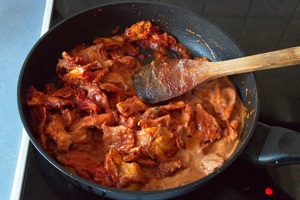 Chicken of the woods mushrooms simmering in tomato and coconut sauce for vegan butter chicken curry