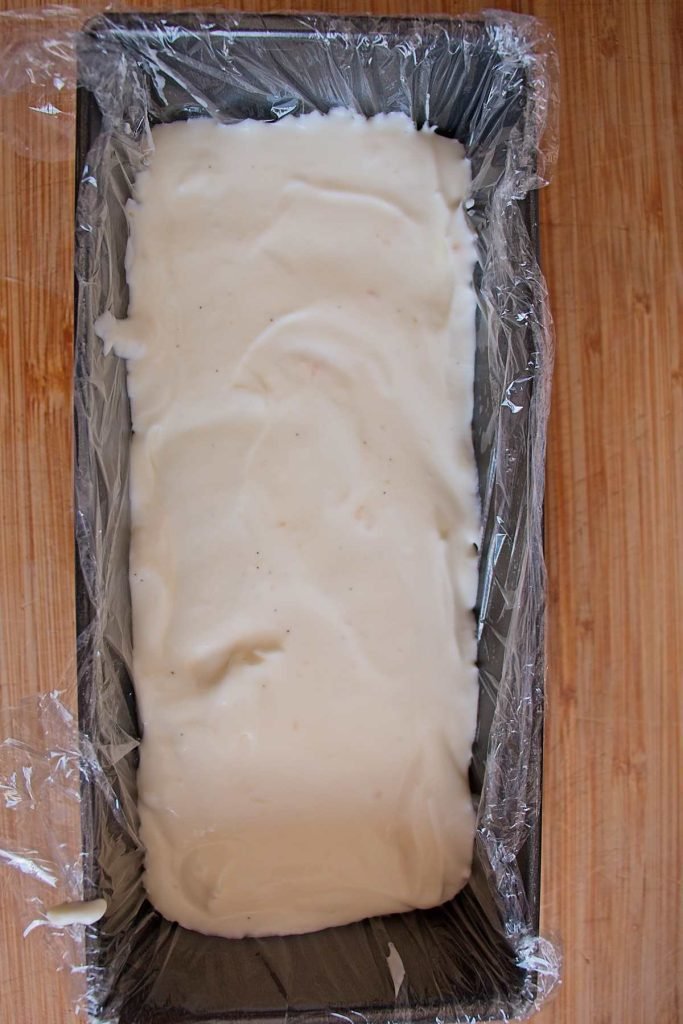 Cardamom and vanilla yogurt mixture layered in a loaf tin lined with cling film.