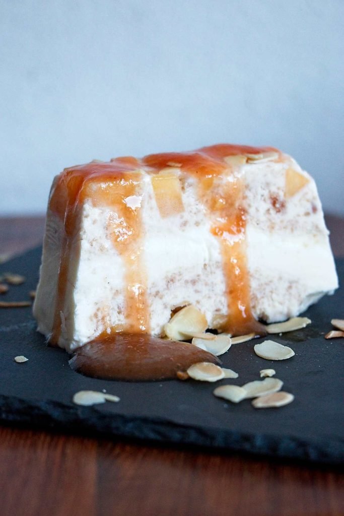 Peach frozen yogurt terrine with cardamom, drizzled with syrup and topped with toasted almonds.