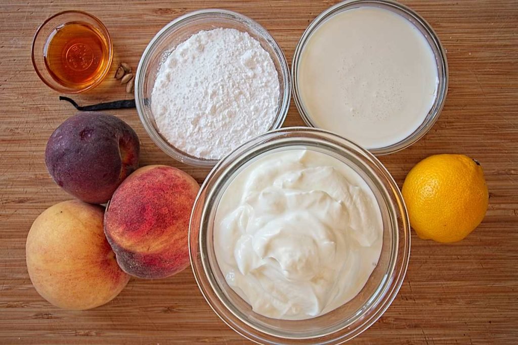 Ingredients for peach and cardamom frozen yogurt terrine, including peaches, yogurt, cream, honey, lemon, and sugar.
