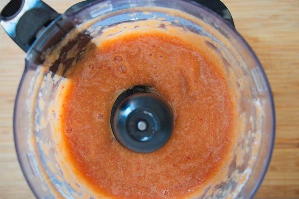 Fresh peach purée blended in a food processor bowl.