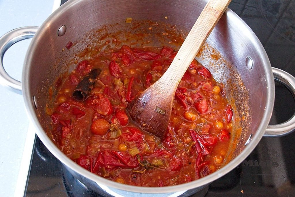 Tomatoes and spices simmering in a pot to make homemade tomato ketchup recipe