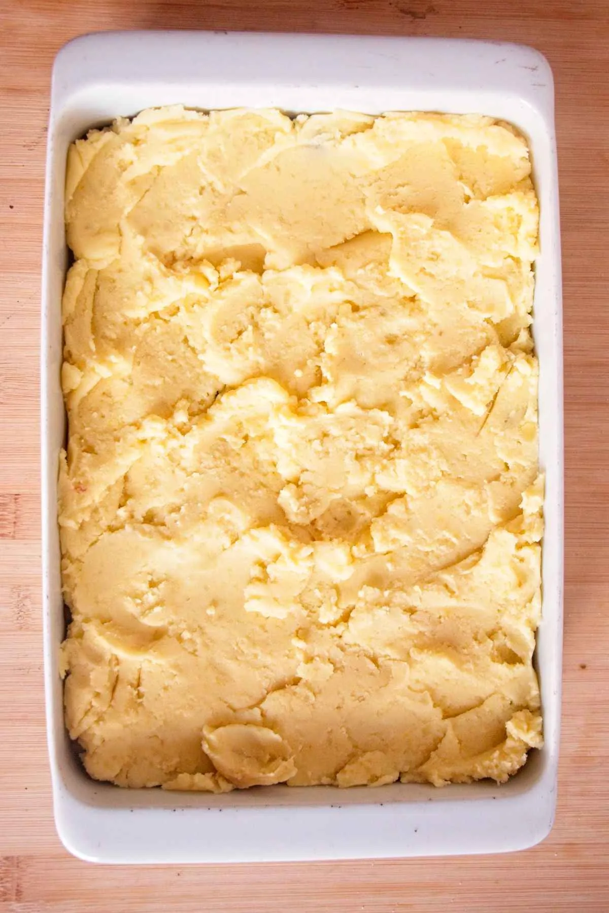 Mashed potato spread over the filling in a baking dish before shaping the top.