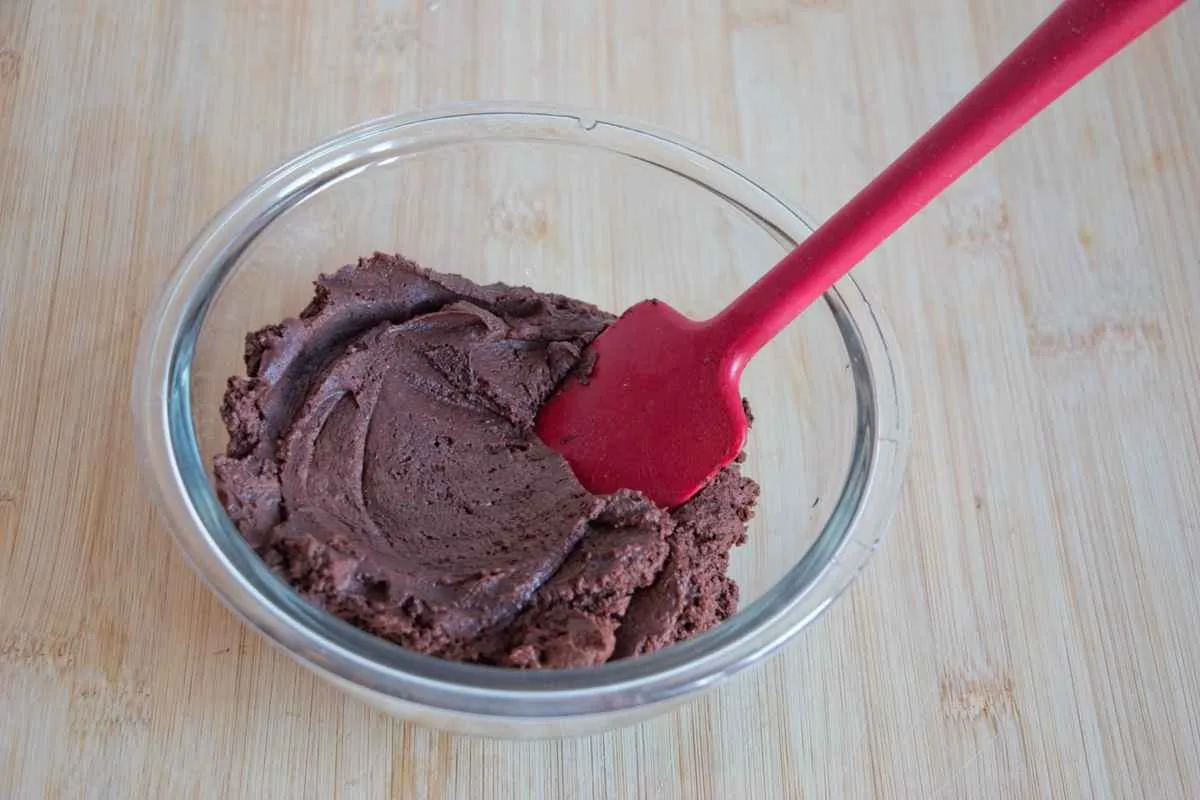 Vegan chestnut truffle mixture in a glass bowl with a spatula.