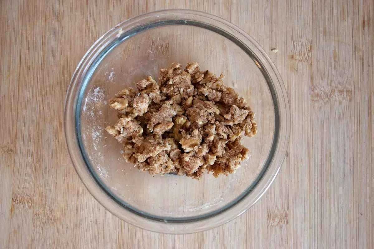 Walnut crumble mixture in a glass bowl after rubbing the ingredients together.