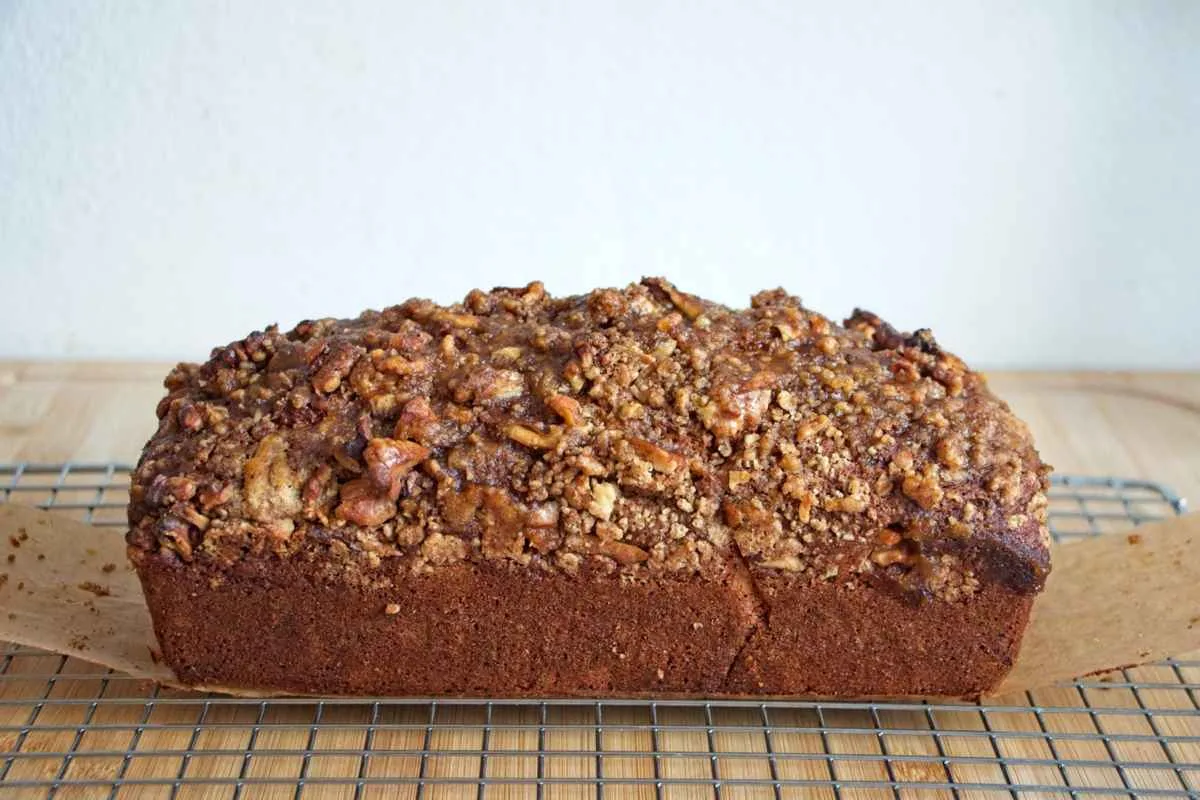 A pumpkin spice and maple loaf with a walnut crumble topping cooling on a wire rack.