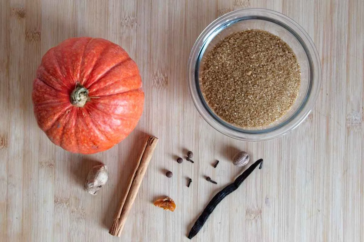 A flat lay of key ingredients for pumpkin spice syrup, made with real pumpkin, brown sugar, and whole spices for rich autumn flavour.