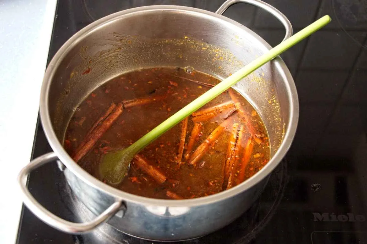Spices simmering in a saucepan to infuse the pumpkin syrup.