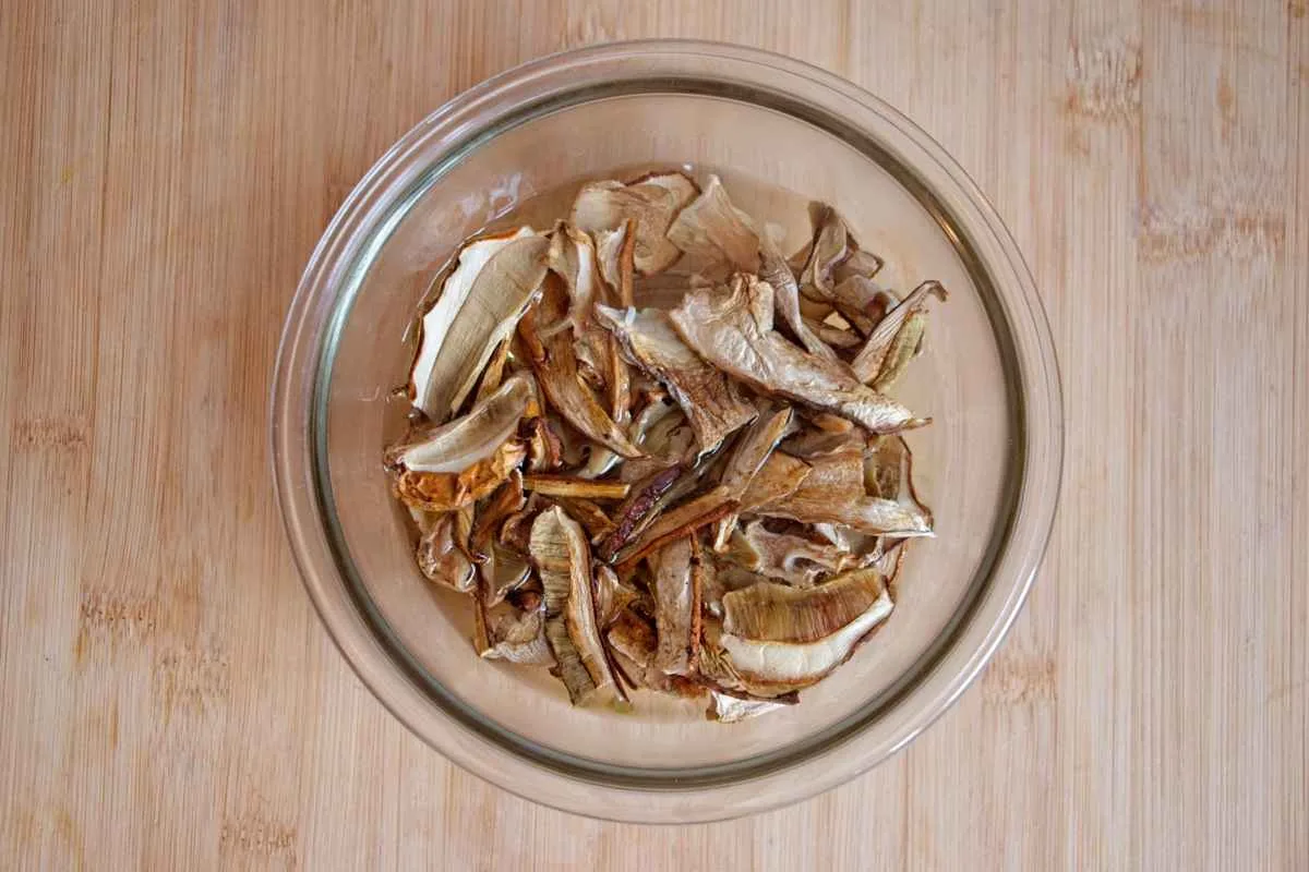 Dried ceps soaking in a bowl of hot water.
