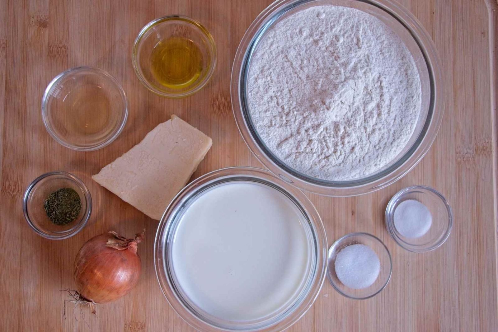 Ingredients laid out for cheddar onion soda bread, including flour, milk, cheddar, onion, thyme, and salt.
