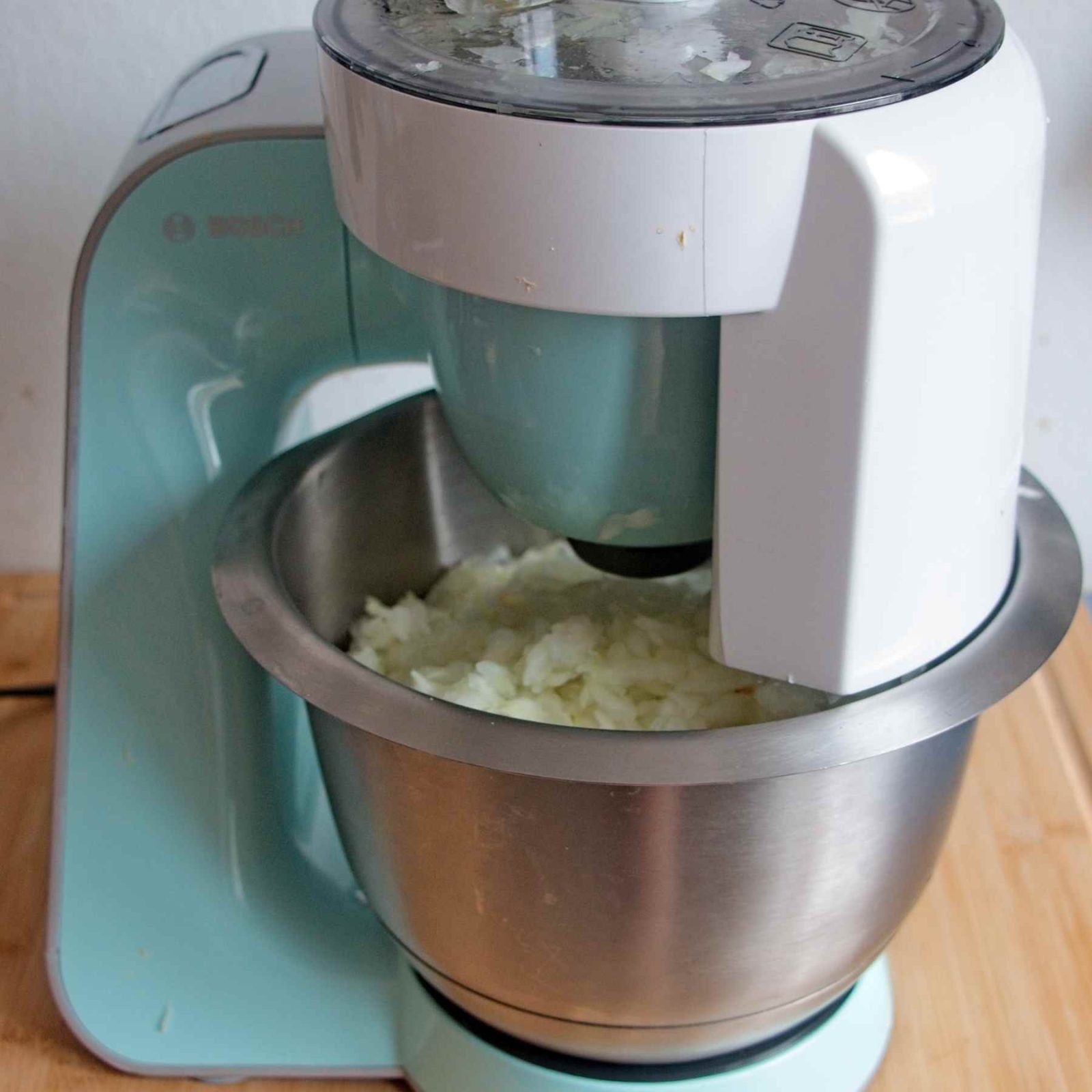Chopping a large batch of onions in a food processor to speed up preparation.