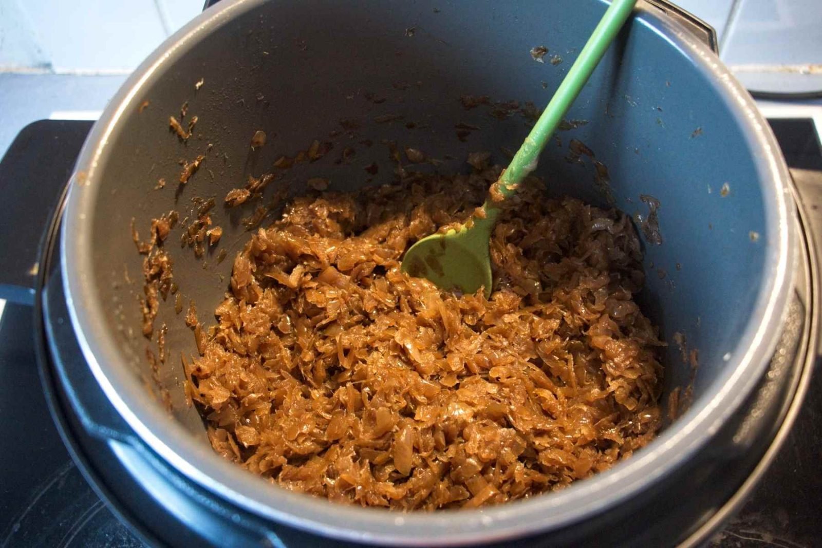 Finishing onions on sauté mode, stirring until thick, glossy, and deeply browned.
