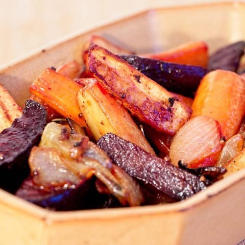 Honey mustard roasted root vegetables with carrots, parsnips, beetroot, and caramelised onions in a rustic serving dish