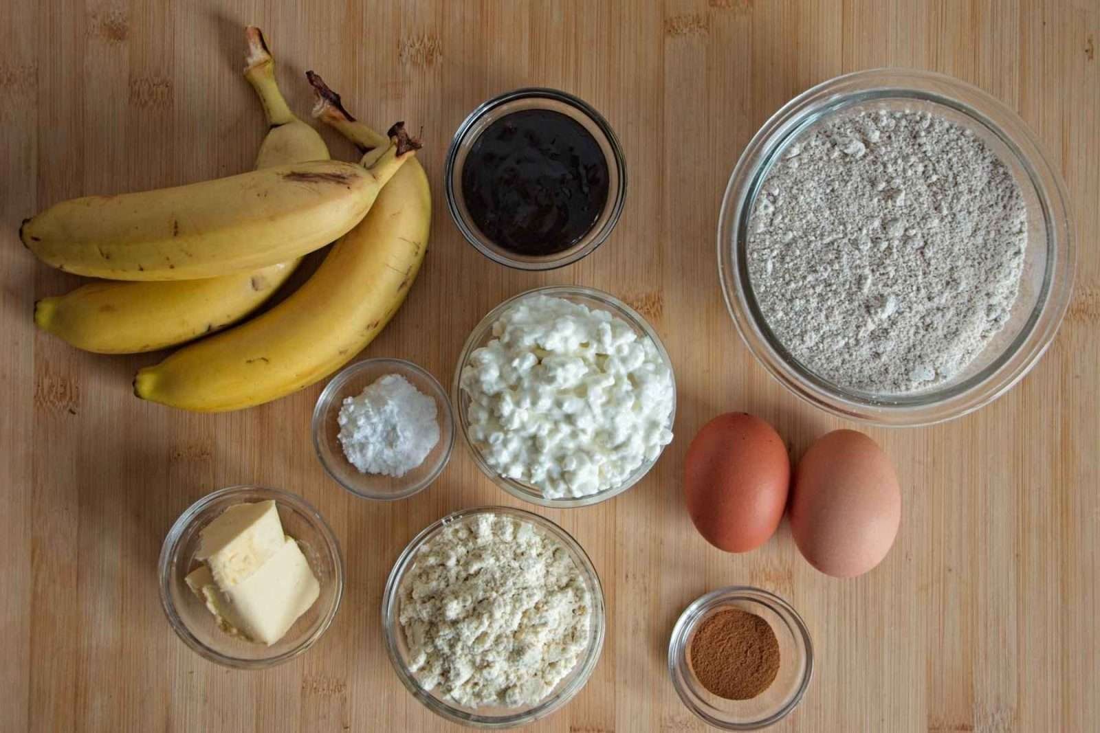 Ingredients for protein banana bread with cottage cheese laid out on a wooden surface.