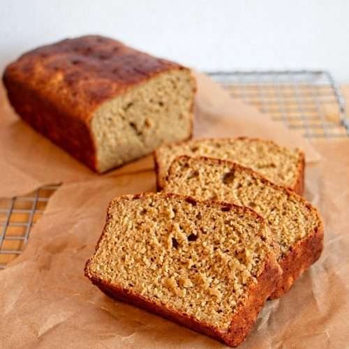 Slices of protein banana bread with cottage cheese cooling on parchment paper.