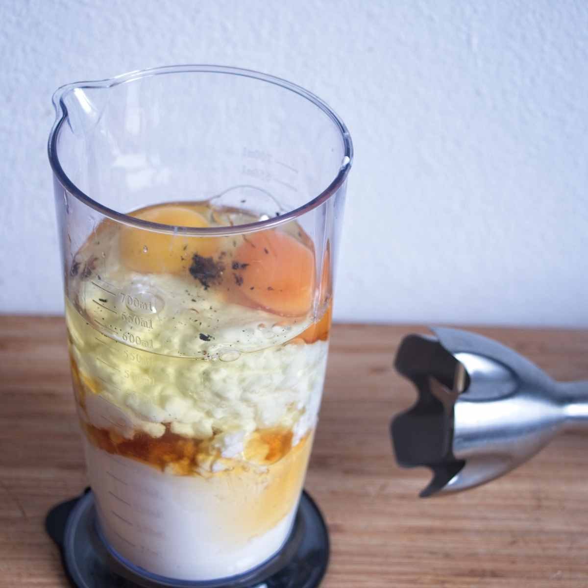 Cheesecake filling ingredients layered in a blender jug before blending smooth