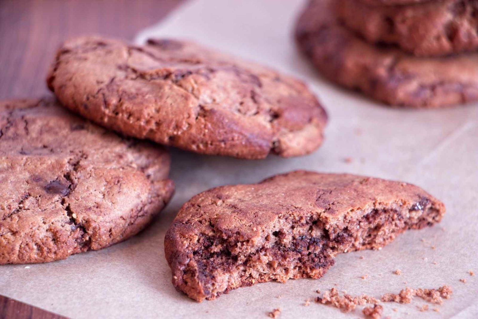 Chocolate peanut butter protein cookies with a broken cookie showing the soft, chewy centre