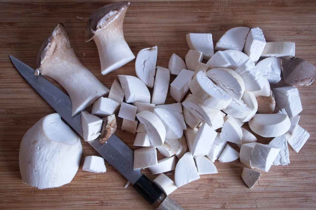 Chopped king oyster mushrooms on a cutting board ready for cooking