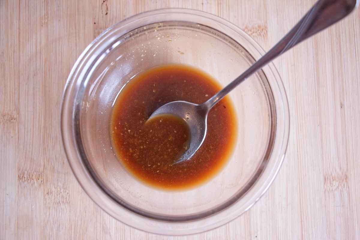 Garlic soy miso glaze mixed in a bowl with a spoon before adding to the pan