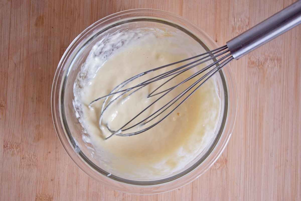 Whisked egg and skyr mixed in a glass bowl on a wooden surface
