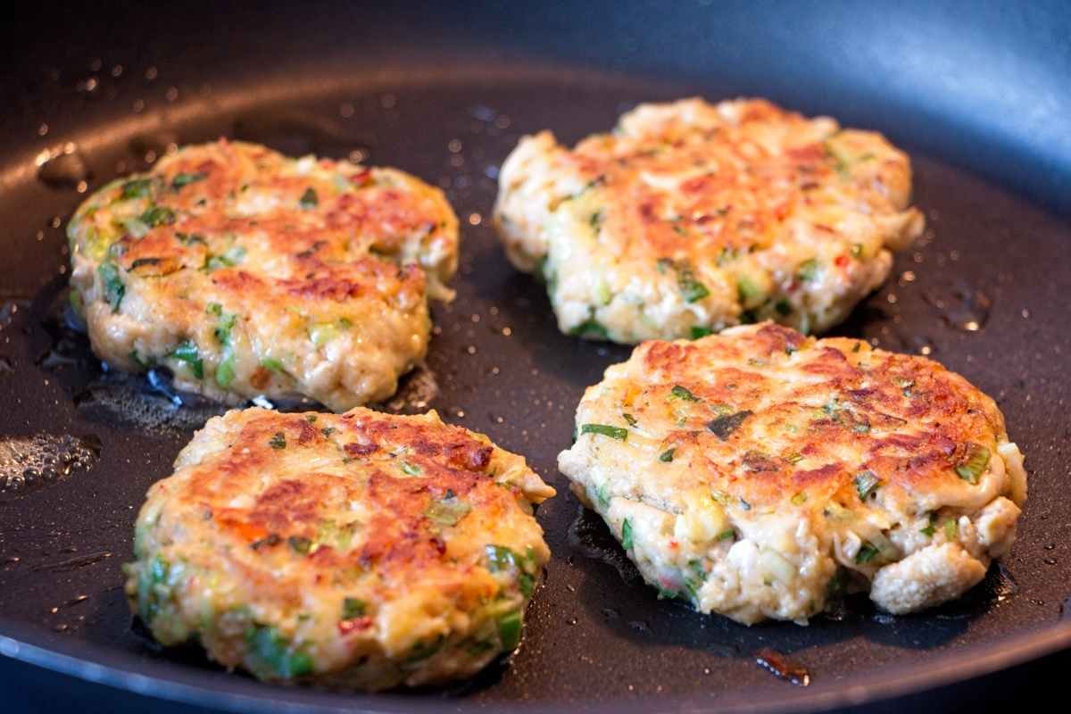 Lion’s mane mushroom crab cakes pan-frying until golden and crisp on the outside.