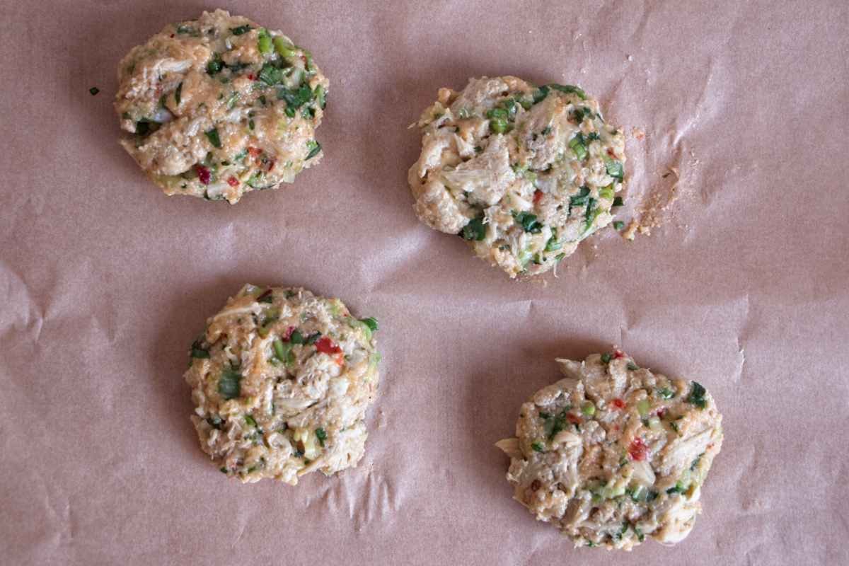 Uncooked mushroom cakes shaped and ready to pan-fry on baking paper.