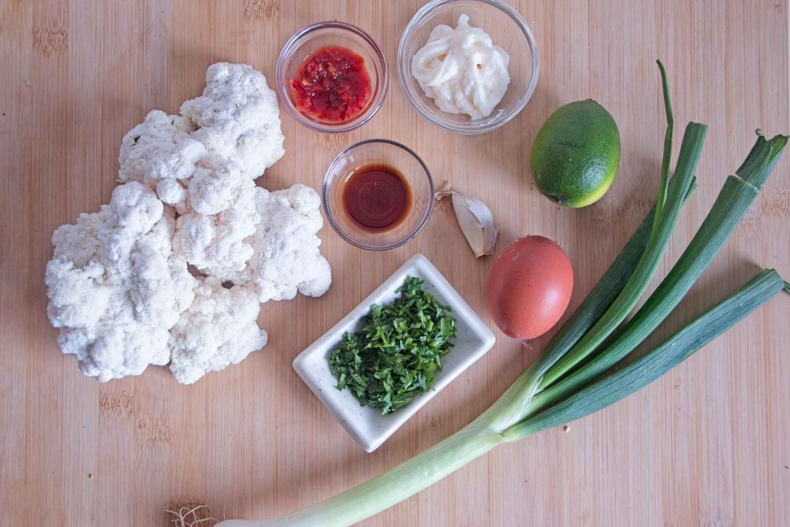 Ingredients prepared for lion’s mane mushroom crab cakes, including mushrooms, spring onions, egg, lime, herbs, and seasoning.
