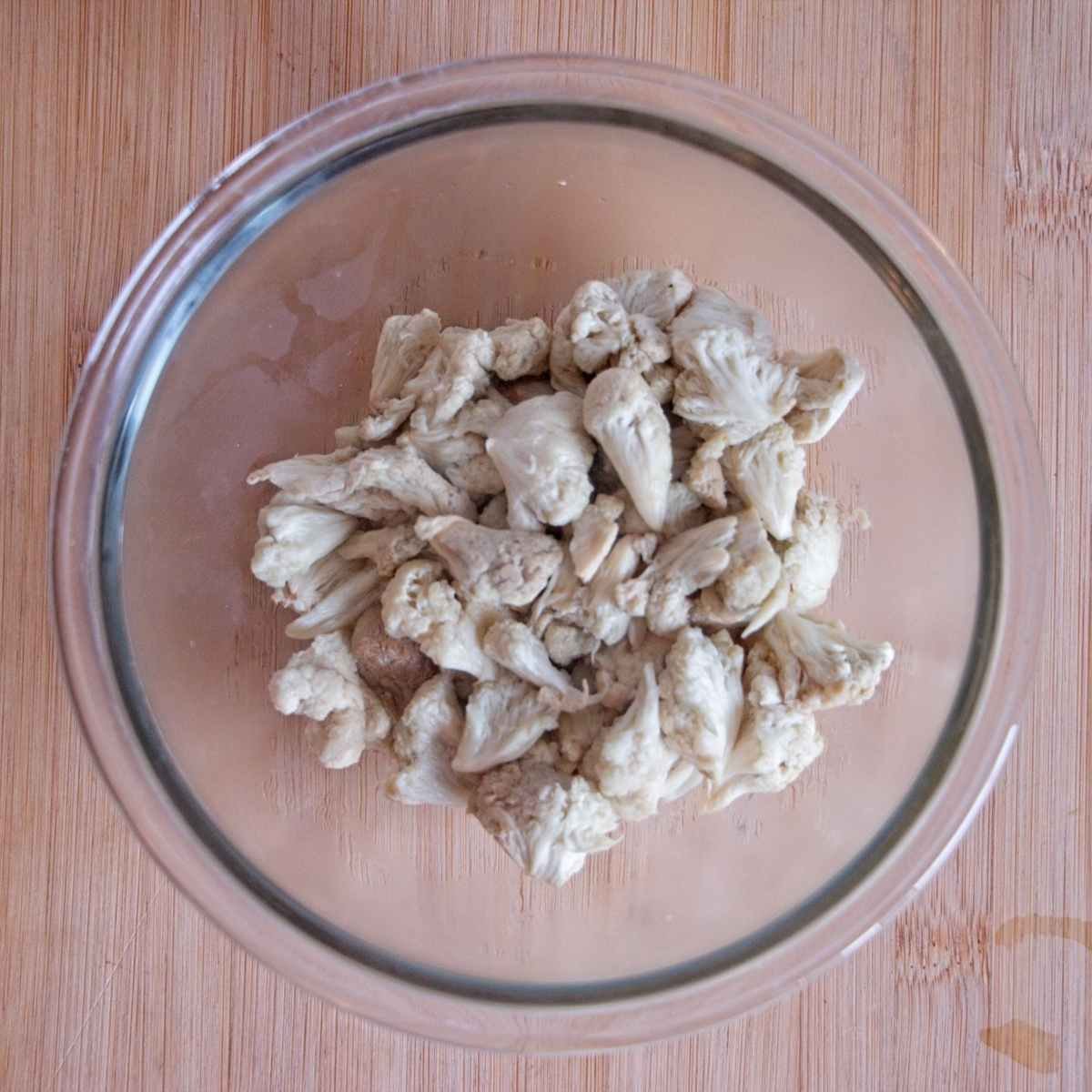 Lion’s mane mushrooms squeezed dry in a glass bowl after wilting.