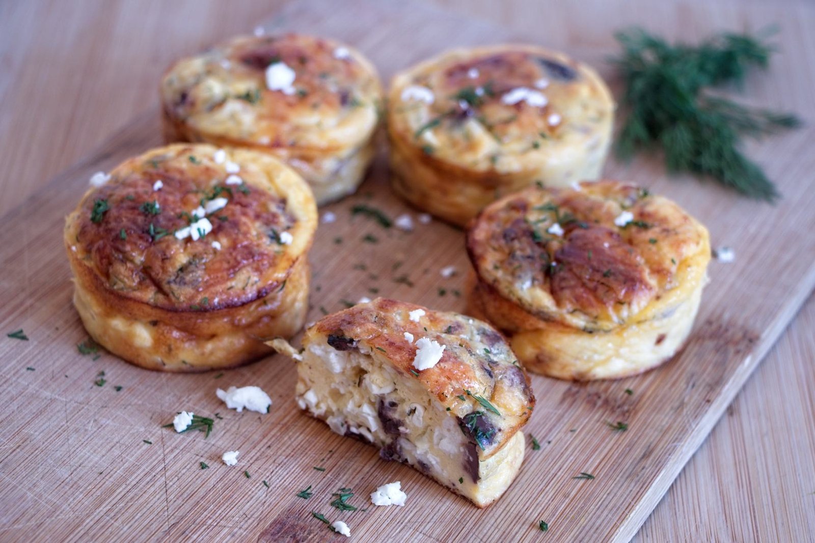 Low carb cottage cheese muffins with feta, dill and lemon on a wooden board