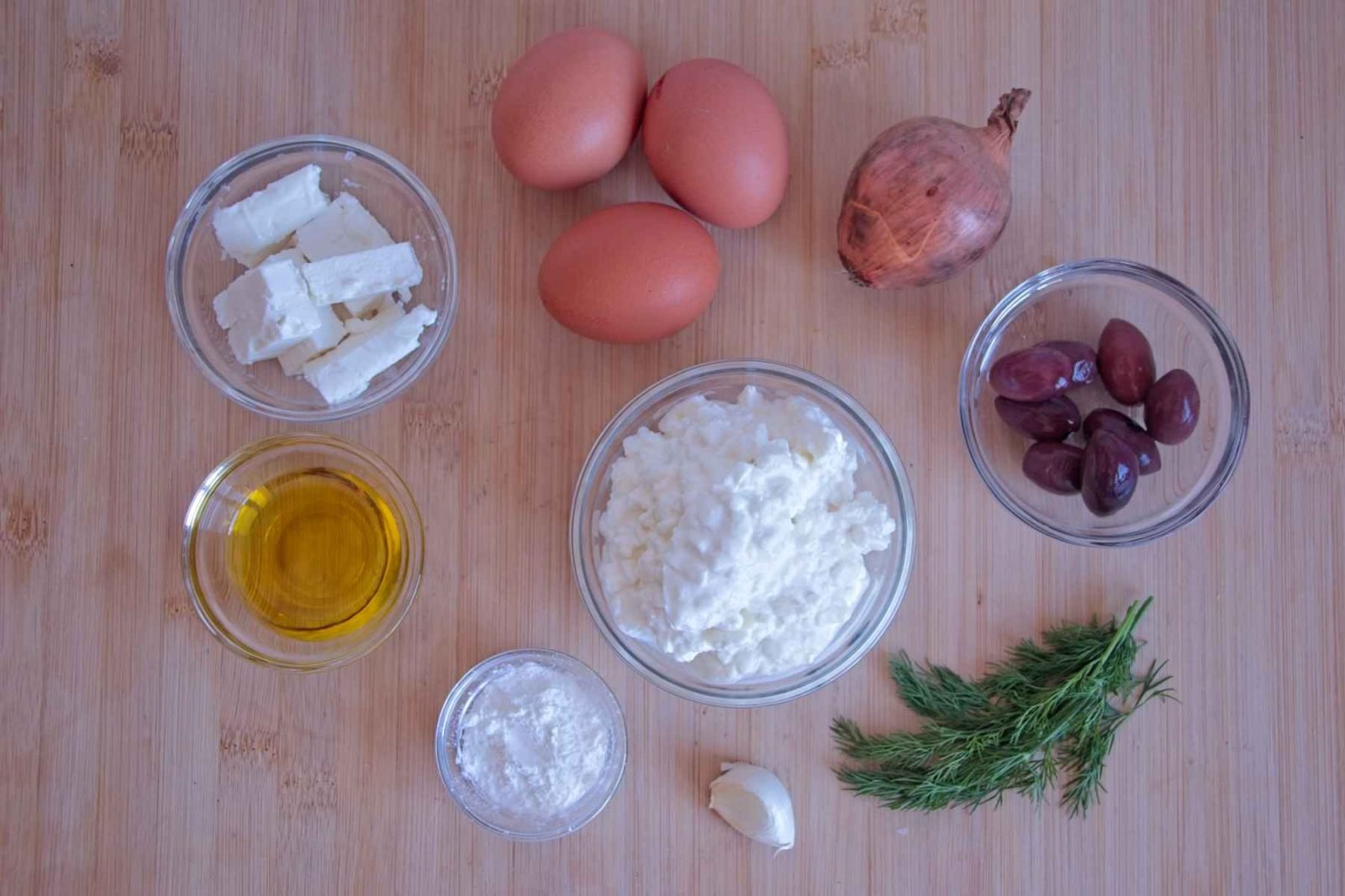 Low carb cottage cheese muffins ingredients including eggs, cottage cheese, feta, olives, dill and olive oil