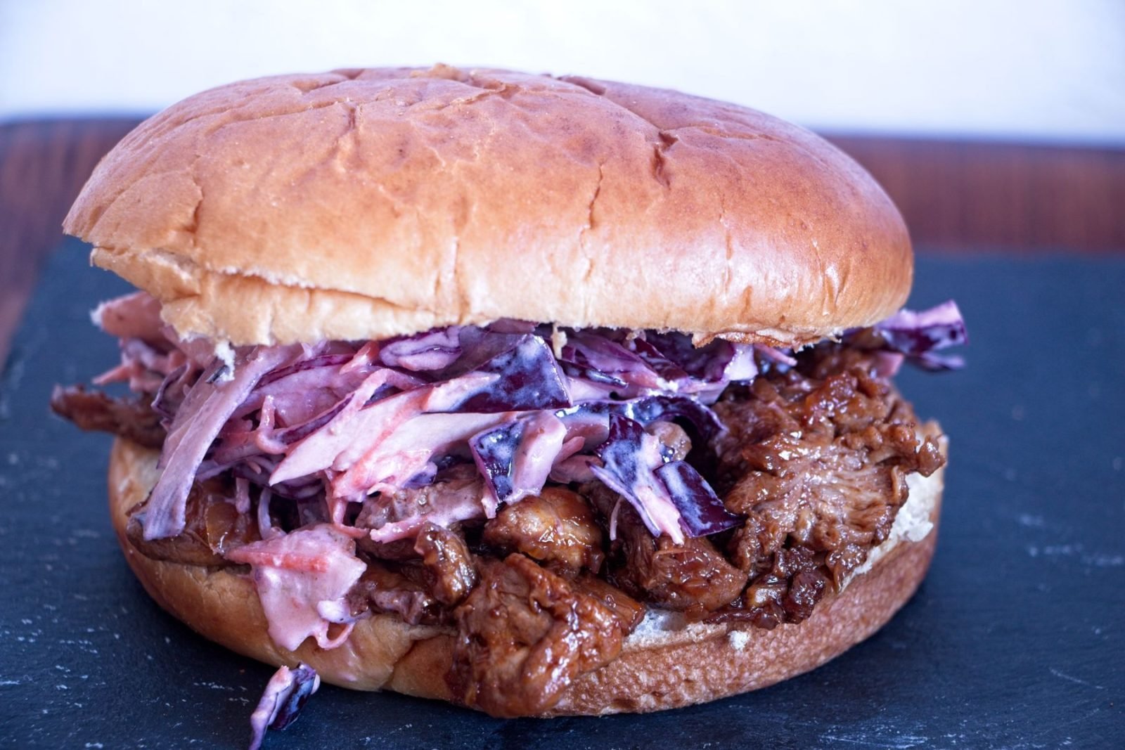 Pulled lion’s mane mushroom sandwich in a soft bun with winter slaw