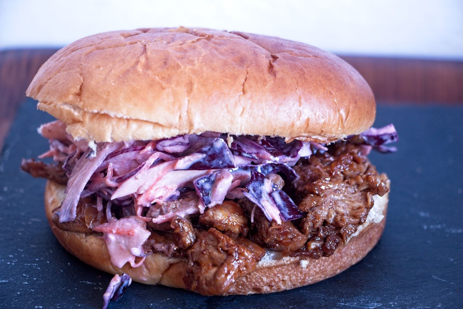 Pulled lion’s mane mushroom sandwich in a soft bun with winter slaw