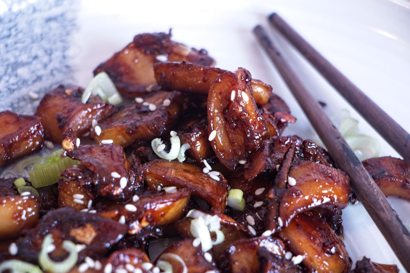 Sticky king oyster mushrooms coated in a garlic soy miso glaze, finished with spring onions and sesame seeds