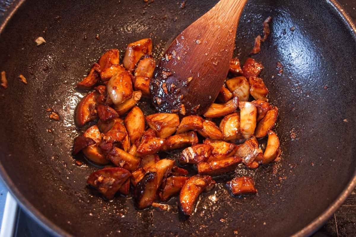 King oyster mushroom pieces cooking in a pan as the garlic soy miso glaze thickens and coats them