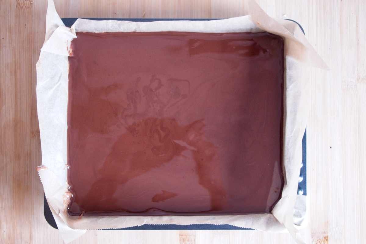 Melted dark chocolate spread evenly over the caramel layer in a lined square tin before chilling