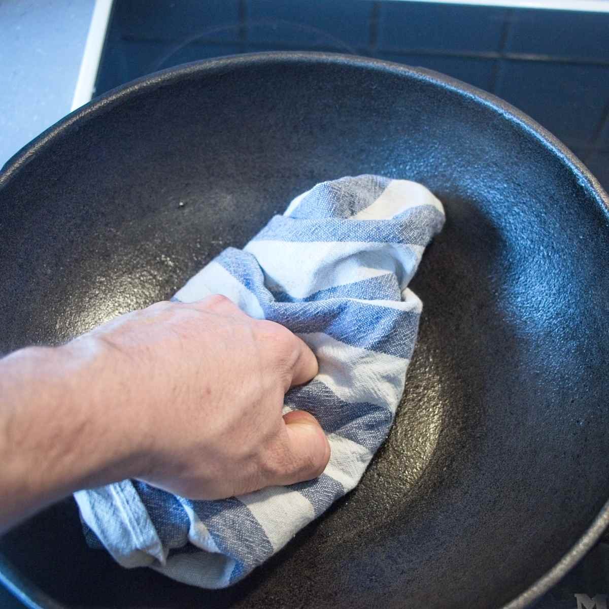 Pressing mushrooms in a hot pan with a cloth to remove excess moisture and improve browning