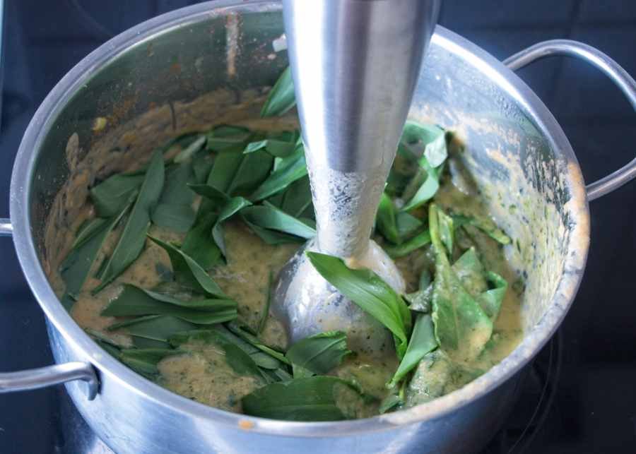 adding fresh wild garlic leaves to the hot ketchup base before blending