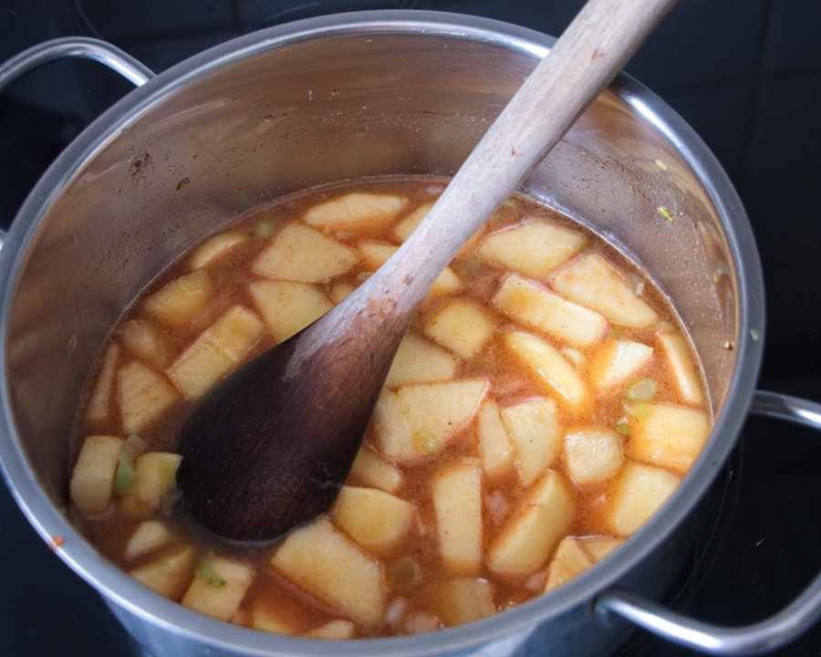 apples simmering in vinegar and spices in a saucepan to make ketchup base