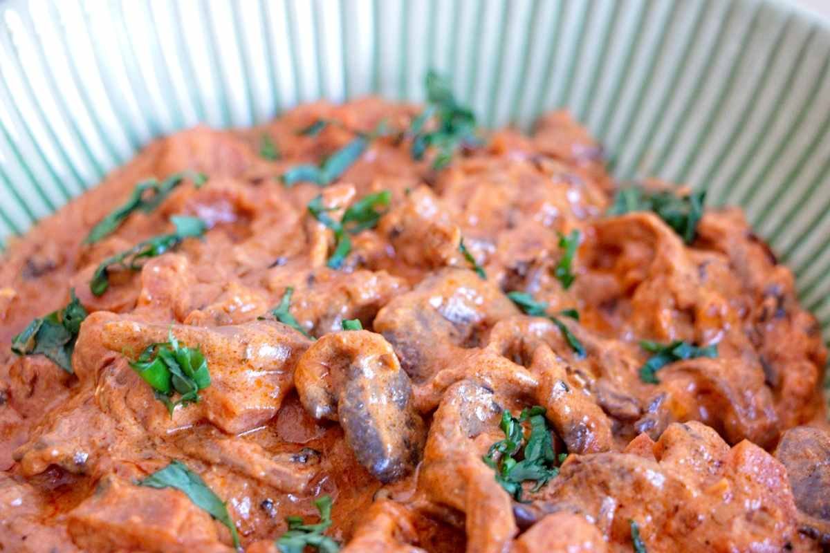 slow cooker mushroom stroganoff with oyster mushrooms in a creamy paprika sauce garnished with herbs