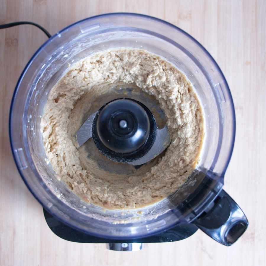 blended chickpeas and tahini in food processor forming hummus base