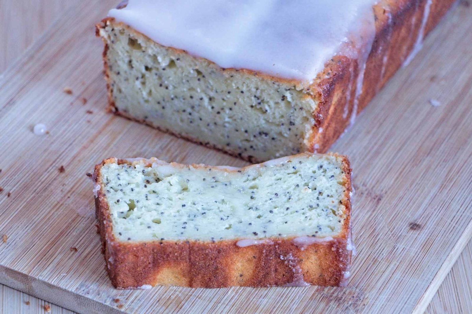 lemon poppy seed skyr cake sliced loaf with lemon glaze on a wooden board