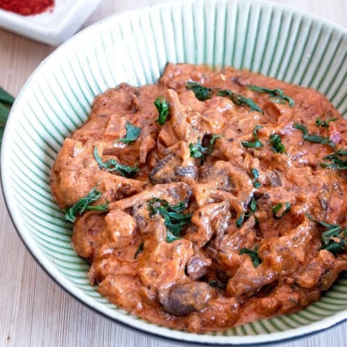 slow cooker mushroom stroganoff with oyster mushrooms in a bowl garnished with fresh herbs