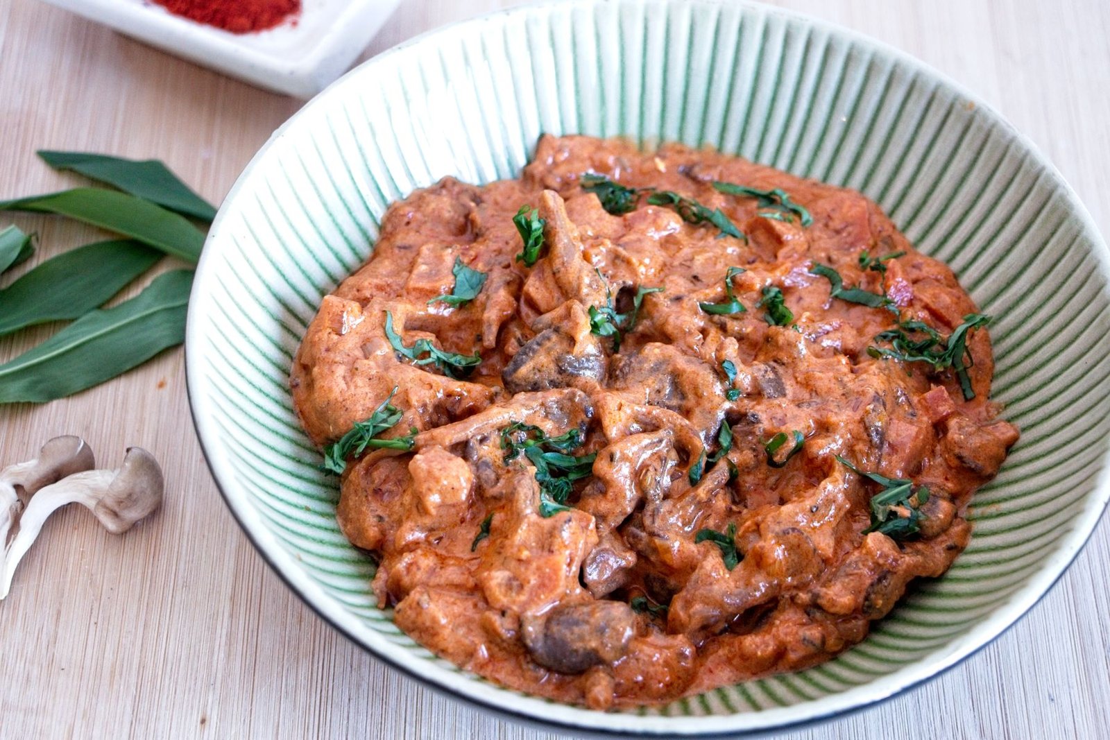 slow cooker mushroom stroganoff with oyster mushrooms in a bowl garnished with fresh herbs