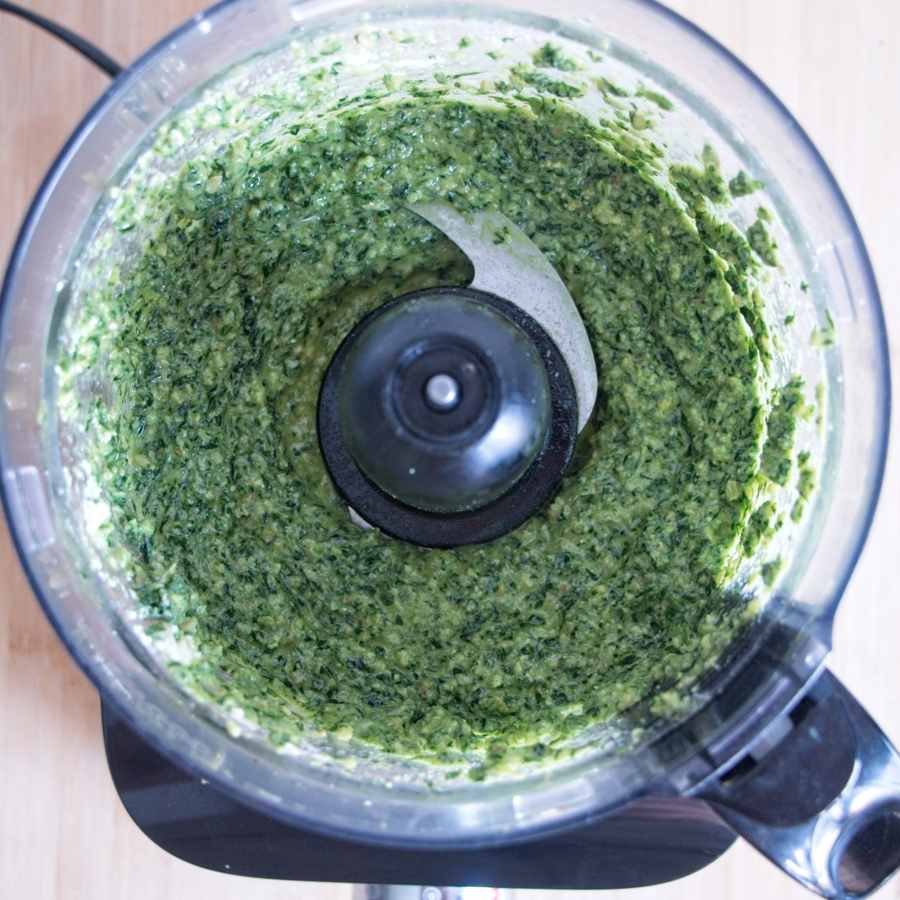 Smooth green pesto blended in a food processor with an even, creamy texture
