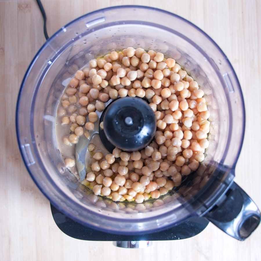 chickpeas in food processor before blending into hummus